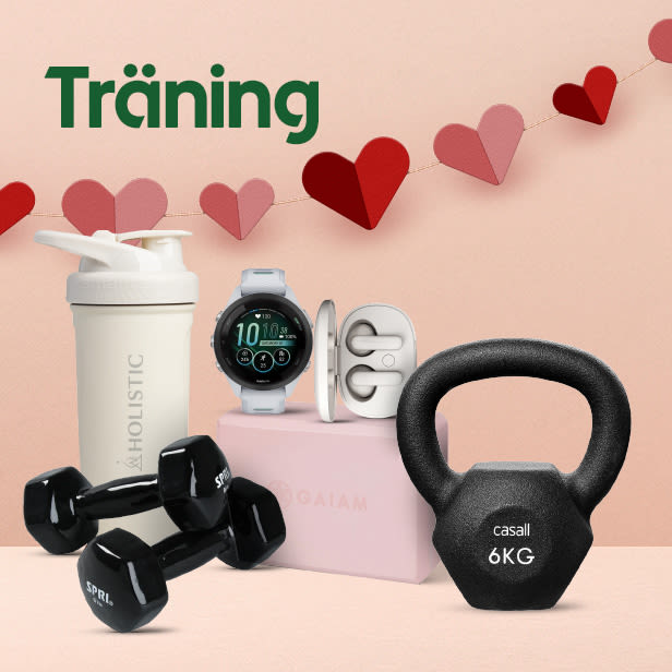 Vitt proteinshaker, svart par hantlar, svart kettlebell på 6 kg, vit smartklocka och vita trådlösa hörlurar på rosa bakgrund med hjärtformad girlang och texten "Träning".