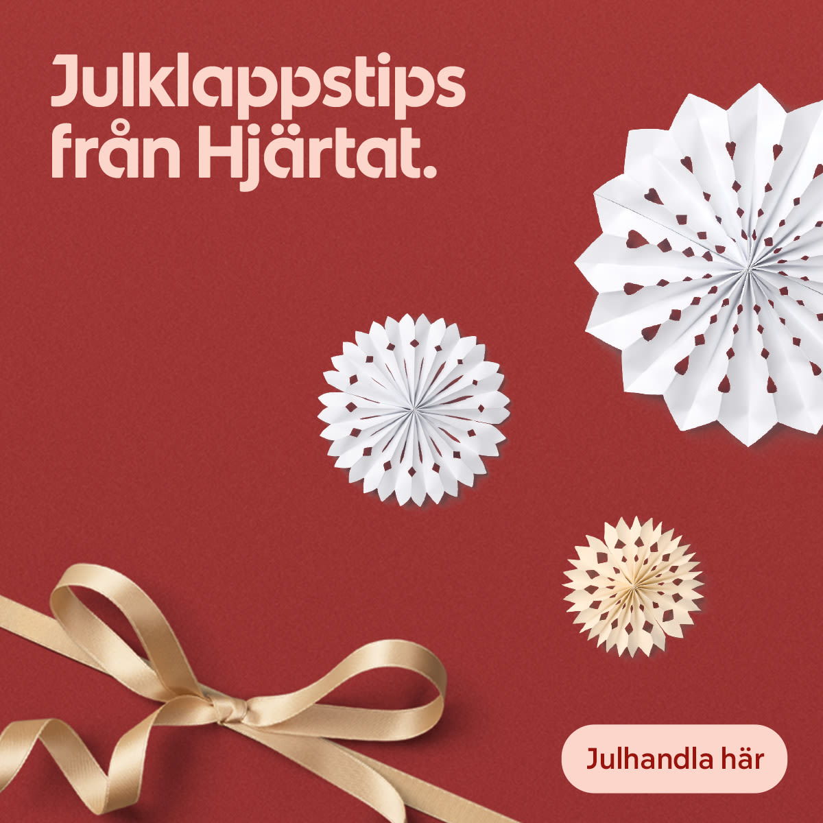 Texten Julklappstips från Hjärtat på röd bakgrund med vita och beige julstjärnor samt ett guldigt sidenband i nedre vänstra hörnet.