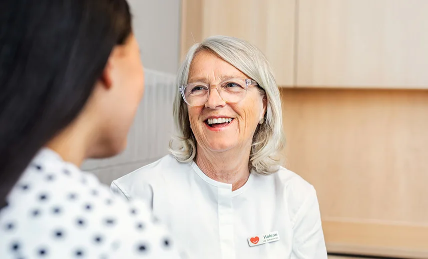 En läkare från Min doktor ler mot en patient.