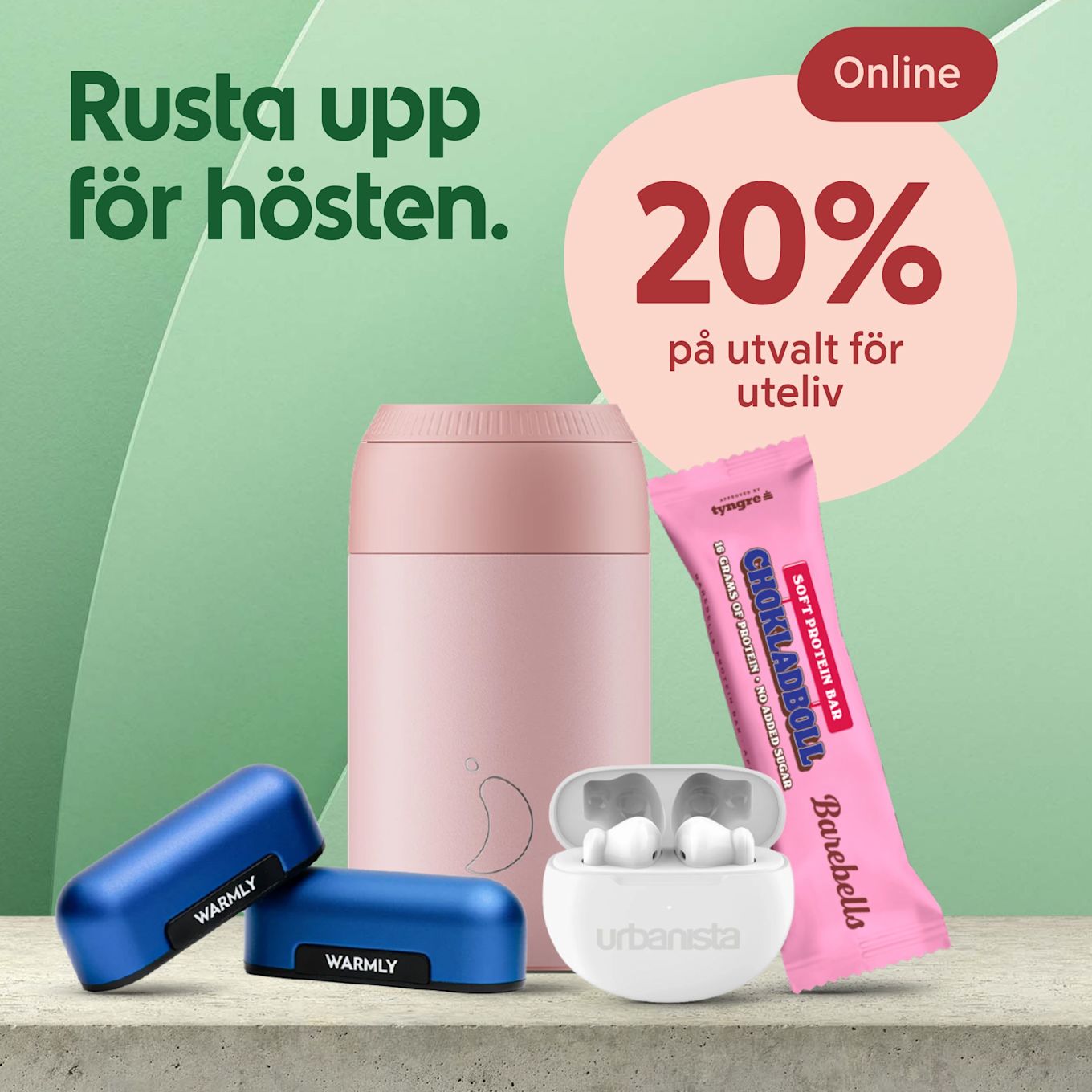 Blå Warmlly handvärmare, rosa termosmugg, vita Urbanista trådlösa hörlurar och rosa Barebells chokladboll proteinbar på bord med text "Rusta upp för hösten" och rabatt 20% online.