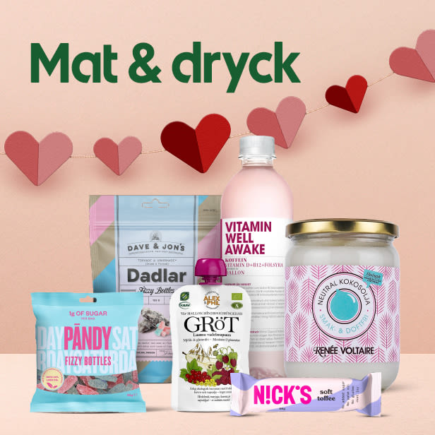 Olika mat- och dryckesprodukter inklusive godispåse, dadlar, vitaminvatten, grötpåse, kokosolja och en toffébar med hjärtdekoration i bakgrunden.