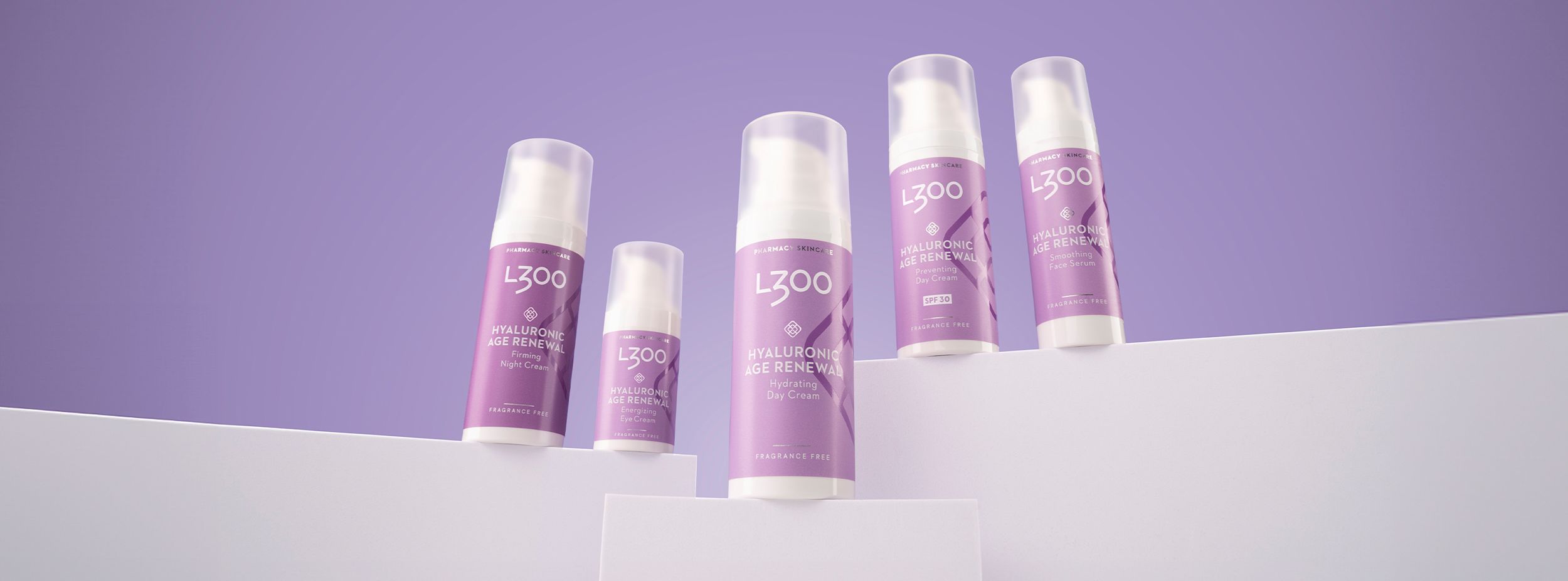 Fem flaskor av L300 Hyaluronic Age Renewal hudvårdsprodukter står uppradade mot en lila bakgrund.